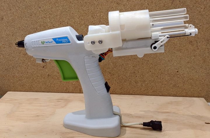 A hot glue gun with a revolving stick holder on the back